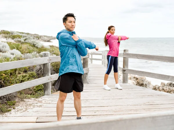 Jovem casal à beira-mar fazendo exercícios — Fotografia de Stock