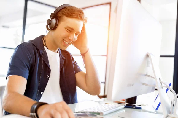 Junger Mann mit Kopfhörern im Büro — Stockfoto