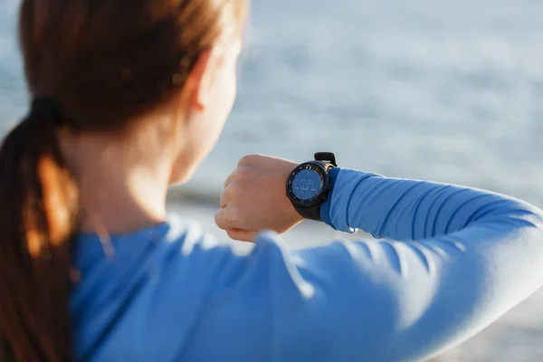 Loper vrouw met hartslagmeter uitgevoerd op strand — Stockfoto