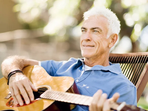 Hombre mayor tocando la guitarra al aire libre — Foto de Stock