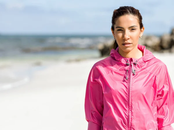 Sportliche Frau in Sportbekleidung steht am Meer — Stockfoto