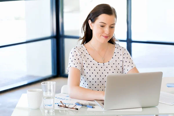 Porträt einer Geschäftsfrau, die im Büro am Computer arbeitet — Stockfoto