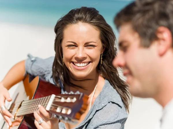 Hermosa joven tocando la guitarra en la playa —  Fotos de Stock