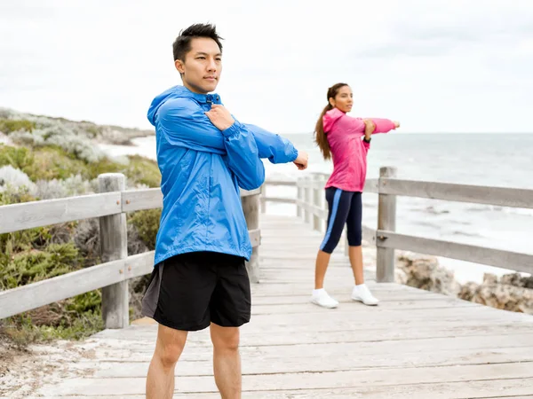 Egzersizleri yapıyor deniz kenarında genç Çift