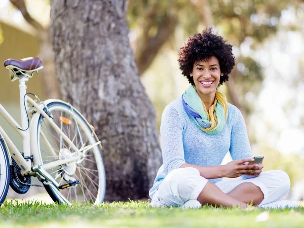 Charming young woman in summer park with mobile — Stock Photo, Image