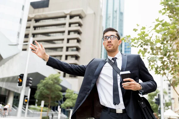 Giovani uomini d'affari in cerca di un taxi — Foto Stock