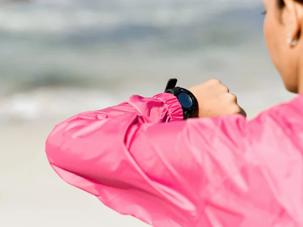 Женщина в спортивной одежде с помощью умных часов — стоковое фото