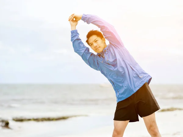 Jonge man doen oefening op het strand — Stockfoto