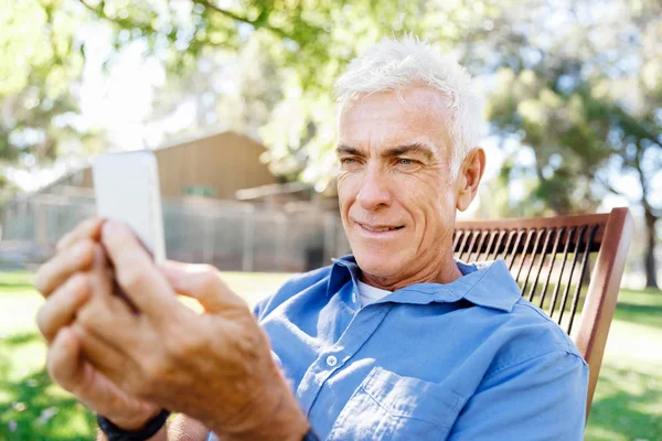LoMature man outdoors using mobile phone — Stock Photo, Image