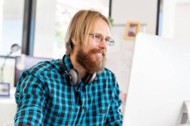 Genç adam ofiste çalışıyor.