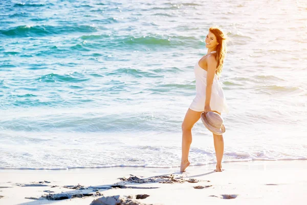 Junge Frau läuft am Strand entlang — Stockfoto
