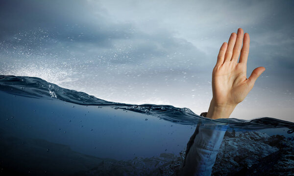 Hand of person drowning in water
