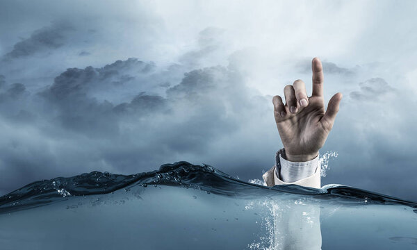 Hand of person drowning in water