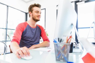 Genç adam ofiste çalışıyor.