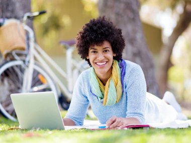 Dizüstü bilgisayar ile bir çayırda açık havada çalışan kadın