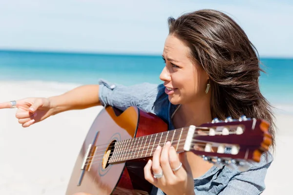 Piękna młoda kobieta gra na gitarze na plaży — Zdjęcie stockowe