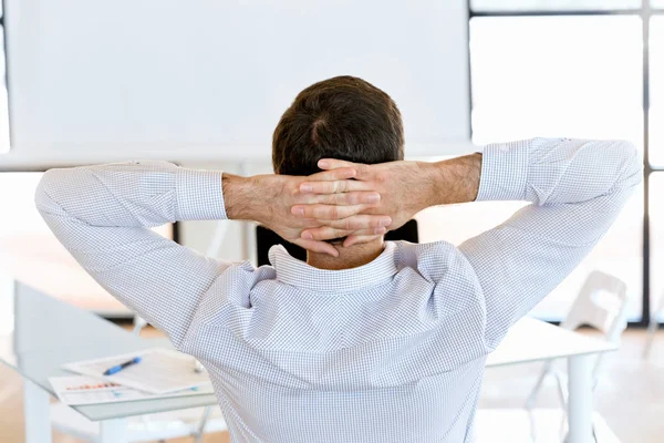 Achteraanzicht van vergadering zakenman met gekruiste handen op het hoofd — Stockfoto