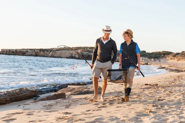 Hombre mayor pescando con su nieto — Foto de Stock