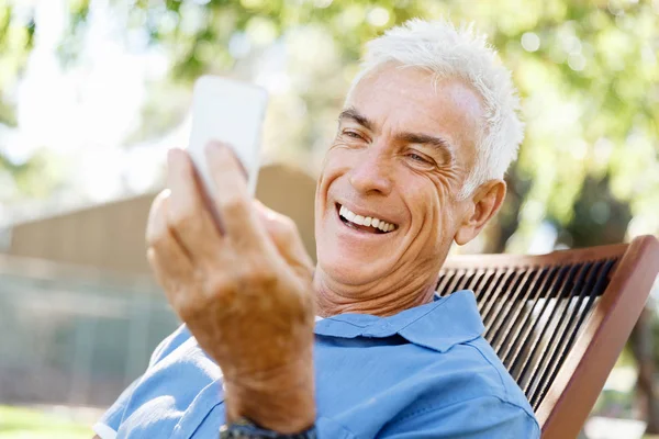 Lomature mężczyzna na zewnątrz przy użyciu telefonu komórkowego — Zdjęcie stockowe