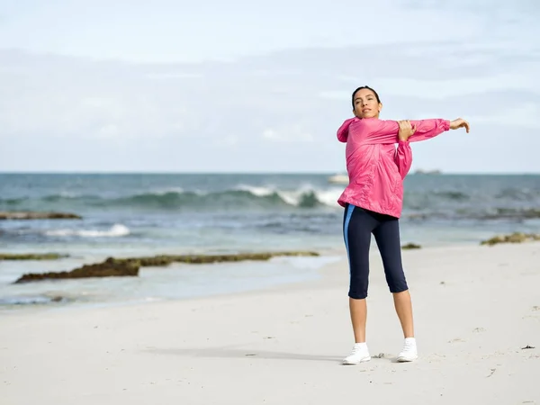 Mujer joven en la playa haciendo ejercicios —  Fotos de Stock