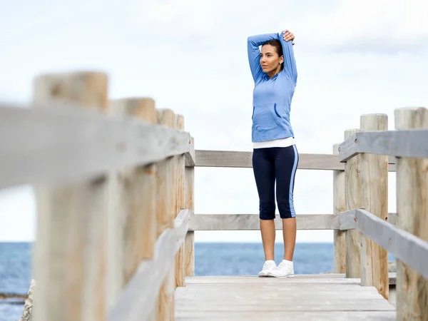 Junge Frau am Strand macht Übungen — Stockfoto