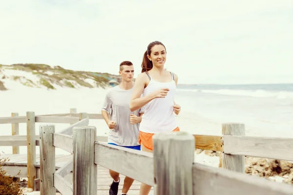 Des coureurs. Jeune couple courant sur la plage — Photo