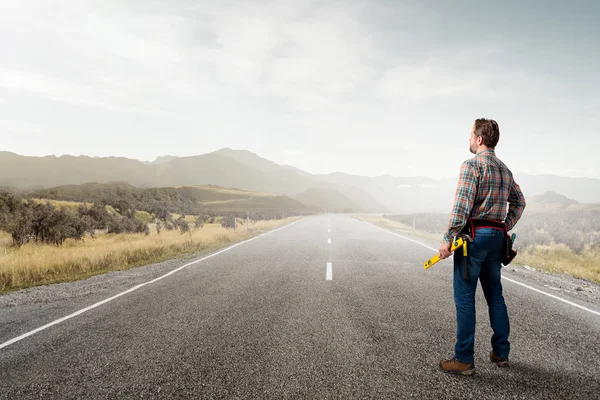 Constructor guapo maduro en uniforme amarillo. Aislado sobre fondo blanco — Foto de Stock