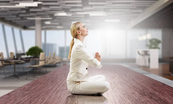 Business lady meditating at work. Mixed media — Stock Photo, Image