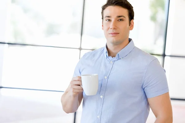 Jungunternehmer im Amt mit Becher — Stockfoto