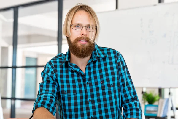 Genç adam ofiste çalışıyor.