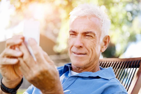 Lomature man buitenshuis gebruik mobiele telefoon — Stockfoto