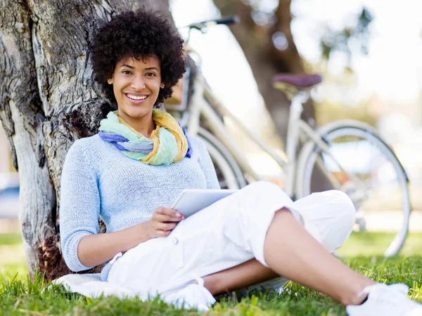 Giovane donna che utilizza tablet nel parco. — Foto Stock