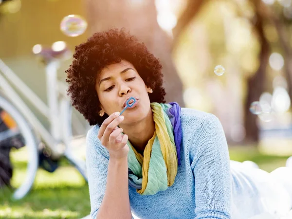 Krásná žena, vyfukování bublin v parku — Stock fotografie