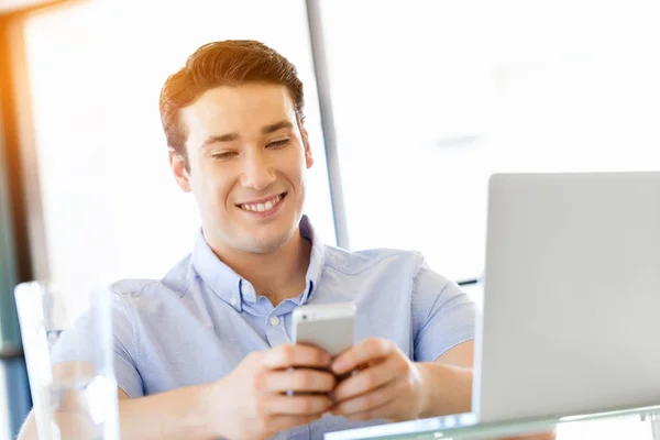 Confident young man in smart casual wear holding phone Stock Picture