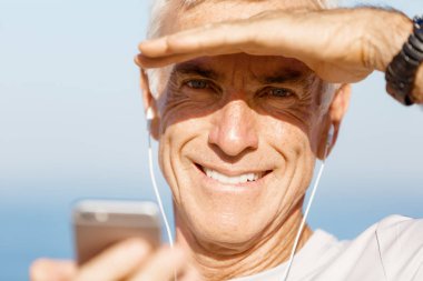 Erkek runner mobil akıllı telefonunu açık havada duran ile