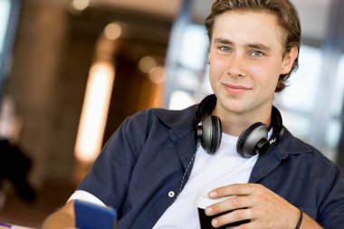 Kendine güvenen genç adam akıllı rahat kıyafet telefon tutarak