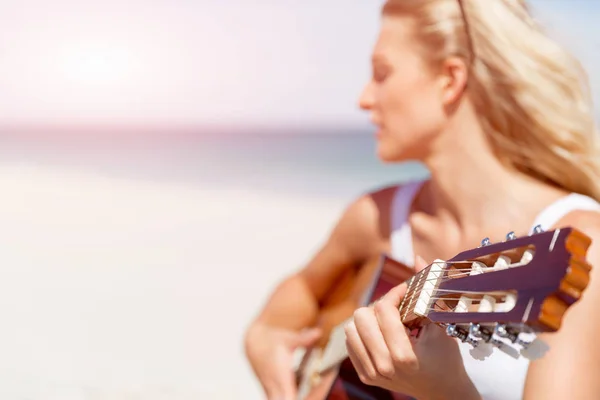 Hermosa joven tocando la guitarra en la playa —  Fotos de Stock