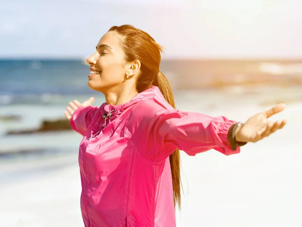 Jonge vrouw met sportkleding tegoed aan zee — Stockfoto