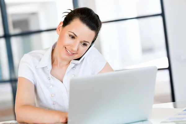 Femme d'affaires avec téléphone portable au bureau — Photo