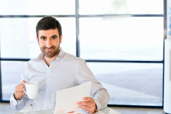 Beau jeune homme tenant du papier en fonction — Photo