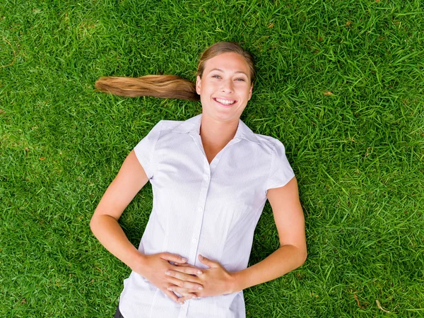 Mujer joven y bonita relajándose en una hierba — Foto de Stock