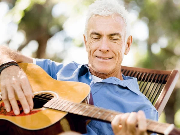 Hombre mayor tocando la guitarra al aire libre — Foto de Stock