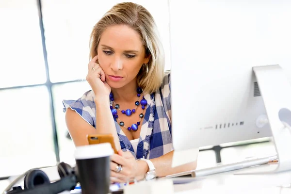 Jonge vrouw in vrijetijdskleding bedrijf telefoon — Stockfoto