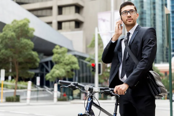 Homens de negócios jovens com uma bicicleta — Fotografia de Stock