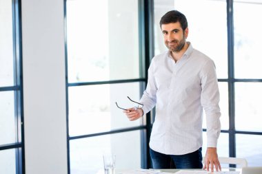 Ofiste duran genç beyaz iş adamı