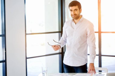 Ofiste duran genç beyaz iş adamı