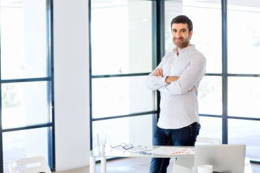 Ofiste duran genç beyaz iş adamı