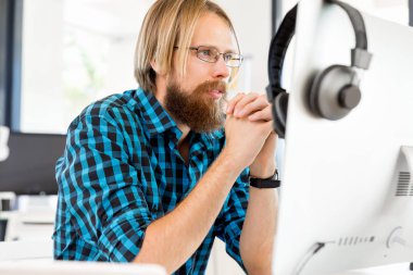 Genç adam ofiste çalışıyor.