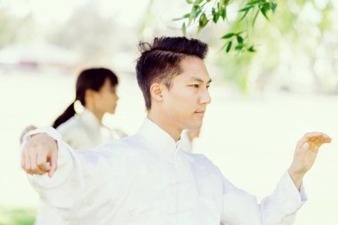 Yakışıklı adam Thai Chi yapıyor.