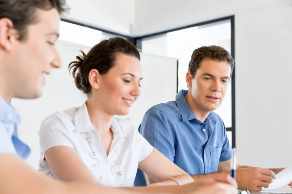 Groep van gelukkige jonge zakenmensen in een vergadering — Stockfoto